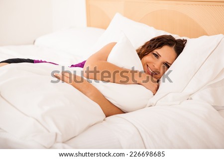 Beautiful young Hispanic woman smiling and about to go to bed in a hotel room