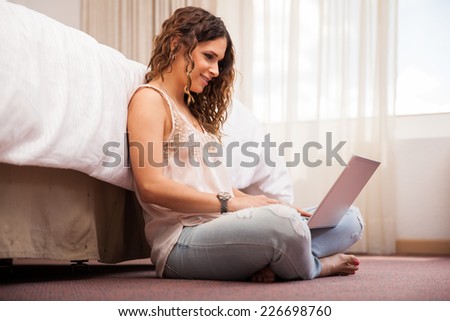 Cute young woman using a laptop computer to keep up with her social networks online