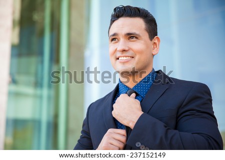 Confident young businessman fixing his tie and getting ready for a business presentation