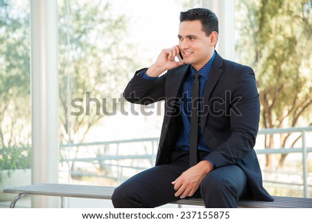 Handsome young lawyer talking over the phone with some clients