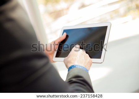 Point of view of a businessman using a tablet computer at work