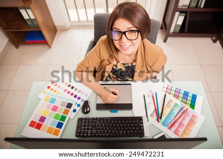 Top view of a cool looking female designer enjoying her job and smiling