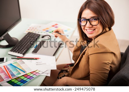 Cheerful female freelance designer doing some work and smiling