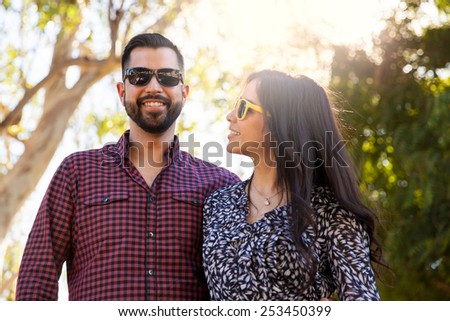 Portrait of a young man hanging out with his girlfriend outdoors and wearing sunglasses