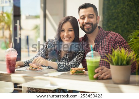 Portrait of an attractive young couple eating lunch together and smiling