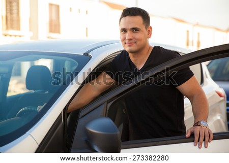 Attractive young man standing next to his car and about to get in