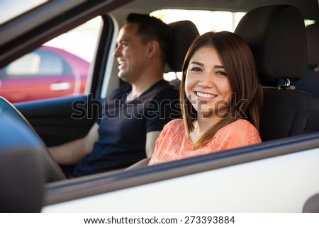 Portrait of a cute brunette driving his date around on her car and smiling