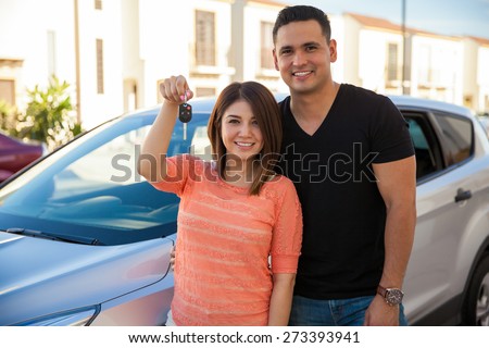Pretty girl and her husband showing off their car keys for their brand new car