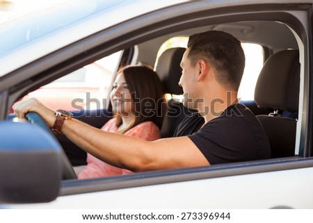Couple of young adults talking and driving to a date on a sunny day