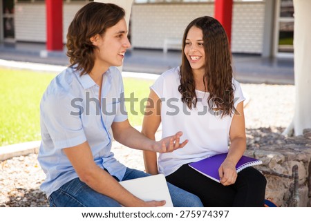 Beautiful curly brunette enjoying her talk with the guy she likes at school