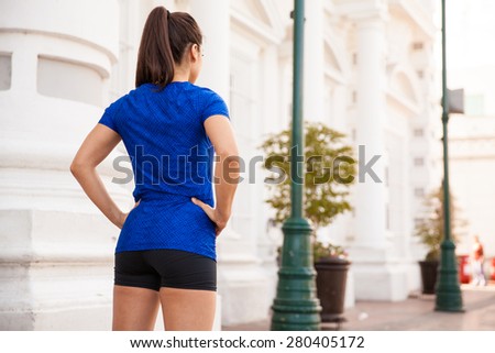 Rear view of a female runner ready to go for a run in the city