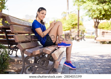 Portrait of a cute young brunette picking a good song and getting ready for her training
