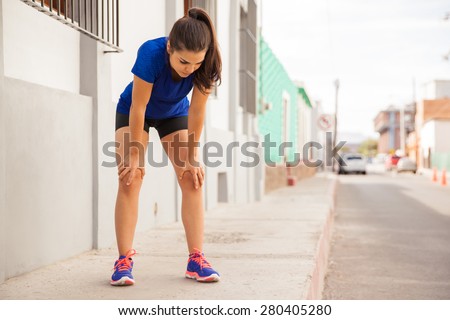 Pretty girl stopping to grab some air after working out in the city