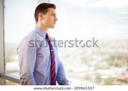 Profile view of a young businessman taking a break from work and enjoying the view in his office