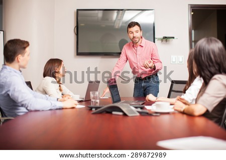 Group of people in a meeting room listening to a man presenting some ideas