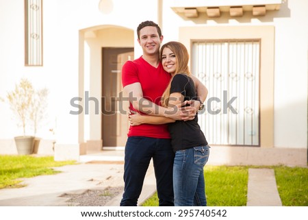 Beautiful young couple embracing each other and excited about the house they just bought