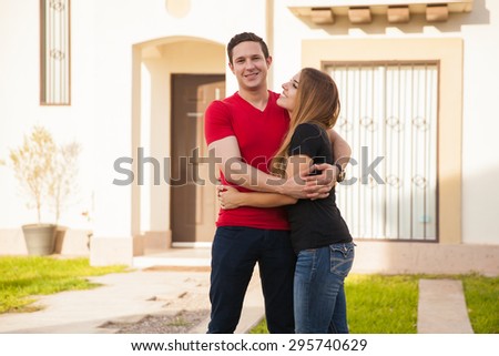 Cute young woman and her husband happy about the house they just bought