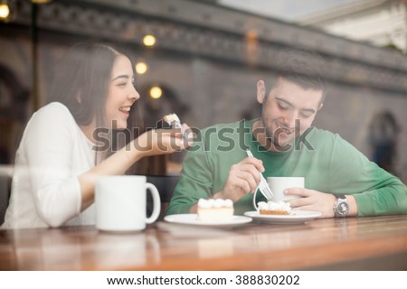 Good looking young couple laughing and having a good time on a date in a coffee shop