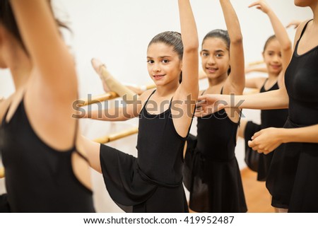 Portrait of a beautiful Latin girl enjoying her dance class among other girls and her teacher