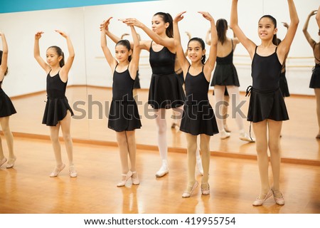 Portrait of a little girl enjoying her ballet class with a group of girls and a dance teacher