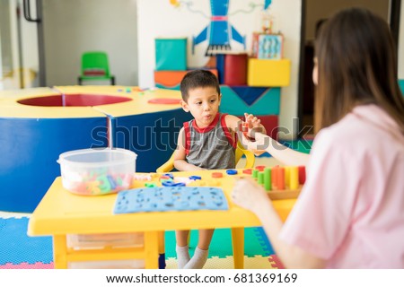 Toddler learning the alphabet with a language therapist in a special education class