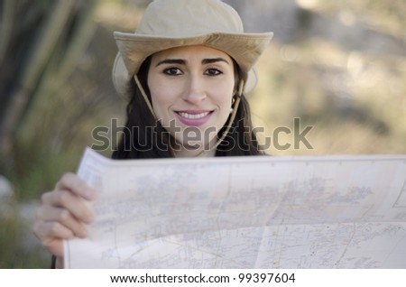 Young beautiful brunette looking at a map on a hiking trip