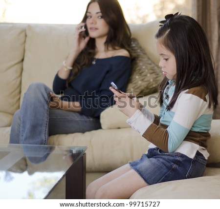 Young mother keeping an eye on her daughter while she talks on the phone