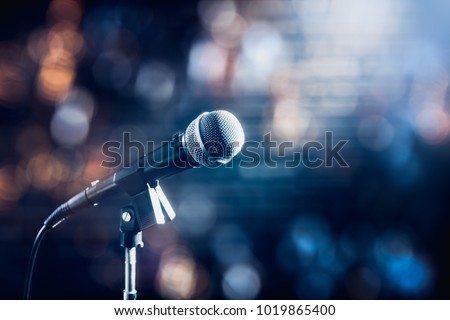 microphone on a stand up comedy stage with colorful bokeh , high contrast image