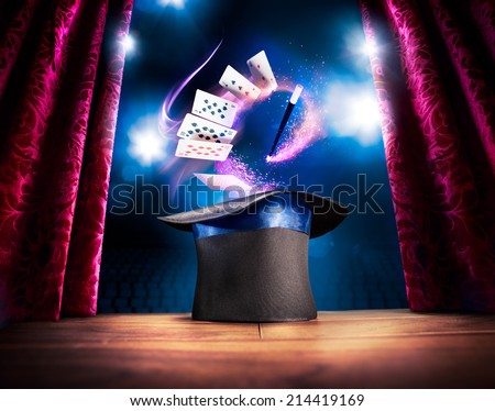 photo composite of a magic hat on a stage with cards and a magic wand