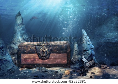 photo of wooden treasure chest submerged underwater with light rays