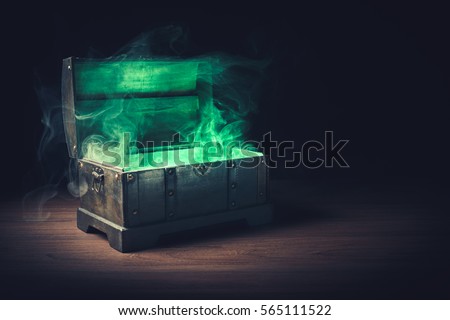 open pandora\'s box with green smoke on a wooden background /high contrast image