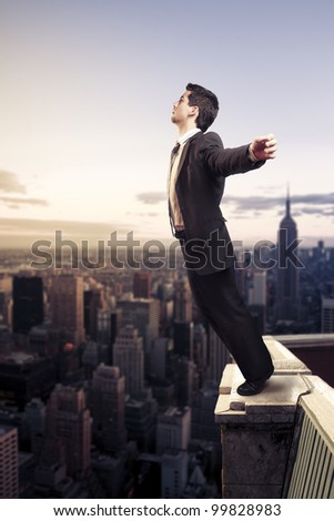 Troubled businessman letting go from the top of a building