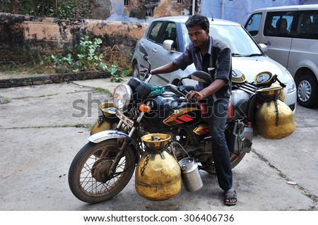 Bundi, India - September 30, 2013 : A milkman is riding his motocycle with milk cans. Milk is a very important food in India, it was drank and used to make dessert.