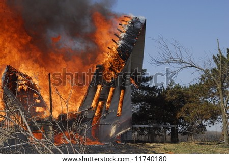 side of burning house falls
