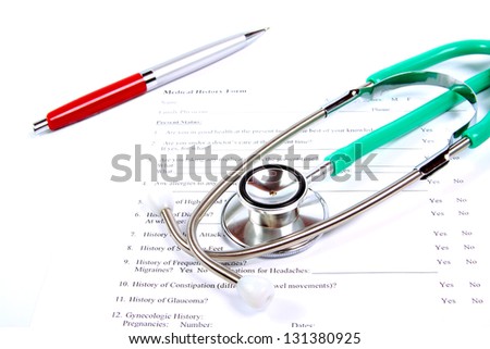 Green stethoscope and a red pen on the medical record form