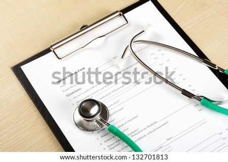 Green stethoscope lying on a medical record (medical history)