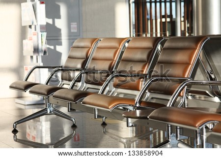 row of brown leather seats in an airport terminal
