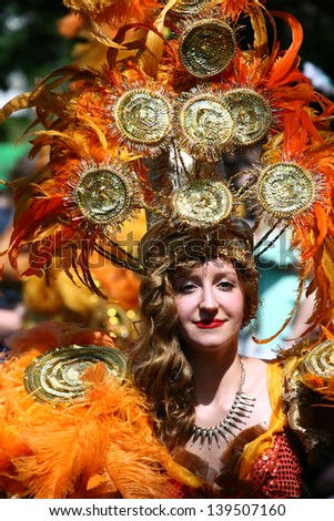 BERLIN - MAY 19: Unidentified young woman dancer dressed in an orange carnival feather costume performs at the annual Berlin Carnival of Cultures on May 19, 2013 in Berlin.