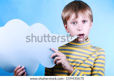 Beautiful funny blond boy holding a blank blue message cloud saying something over blue background