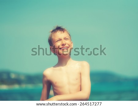 Cute cheerful child playing in sea laughing. Summer break concept.