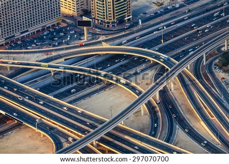 Aerial view of highway road intersections with traffic in a big city (Dubai) at sunset. Transportation concept.