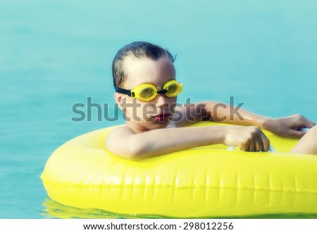Funny child with beach toys enjoying summer vacation relaxing in sea. Summer break and tourism concept.