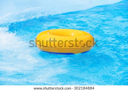 Yellow inflatable float in pool in water park. Summer recreation and sports concept.