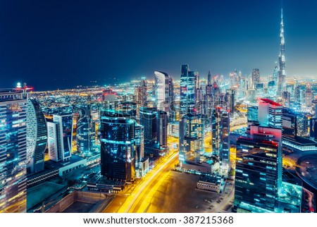 Aerial view of a big modern city by night. Business bay, Dubai, United Arab Emirates. Nighttime skyline.