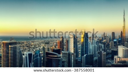 Dubai\'s business bay with many modern skyscrapers. Beautiful aerial cityscape by colorful sunset.