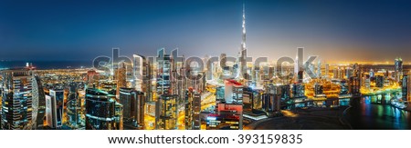 Aerial panoramic view of a big futuristic city by night. Business bay, Dubai, United Arab Emirates. Nighttime skyline.