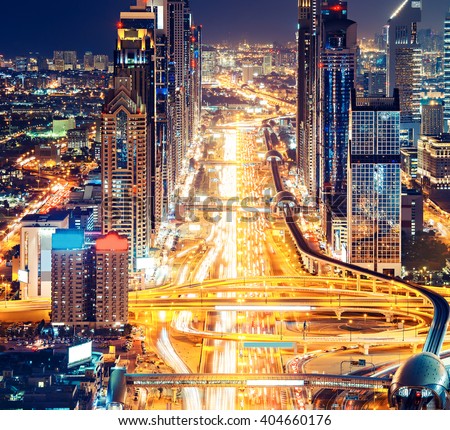 Downtown Dubai architecture by night. Aerial view of illuminated skyscrapers and highway. Famous travel destination.