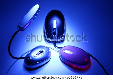 Artistic concept of symmetrical arrangement including portable lamp and  two  computer mice in the darkness (night work)