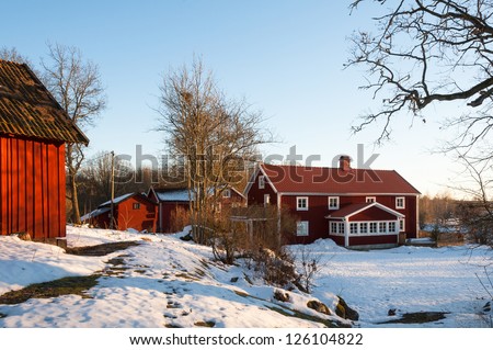 Typical red wooden houses in the country side of southern Sweden