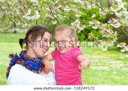 Mother and Daughter enjoying a funny moment while taking a walk in the park in spring
